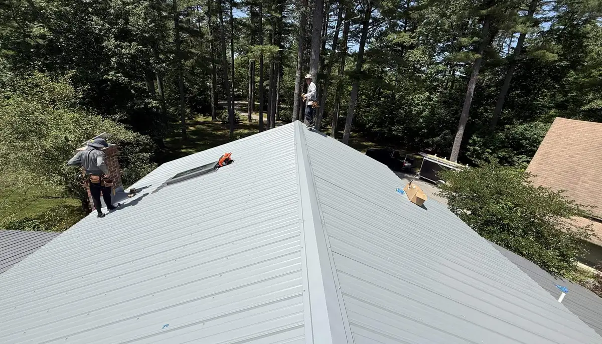 Crew installing an exposed-fastener metal roof