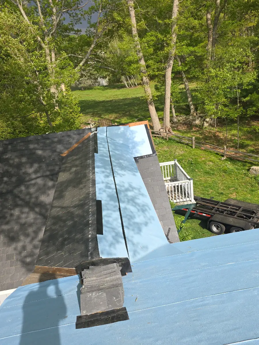 Metal edge flashing over high-temperature ice and water shield on a slate roof job